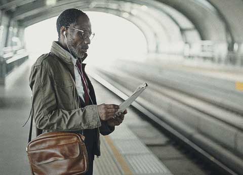 Commuter reading the paper while waiting for a train